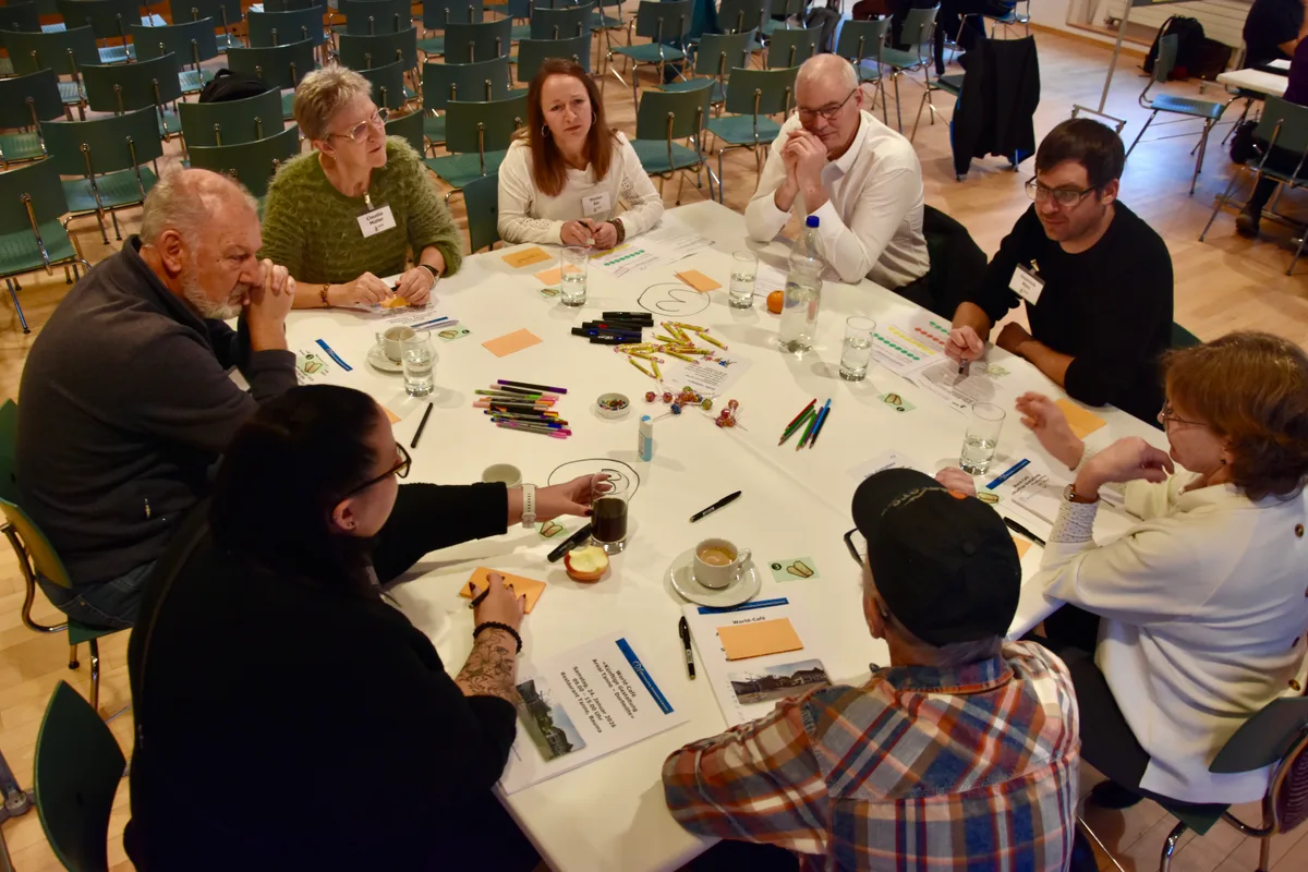 Eine Gruppe diskutiert an einem Tisch. 